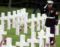 Marine saluting at cemetery for fallen soldiers.